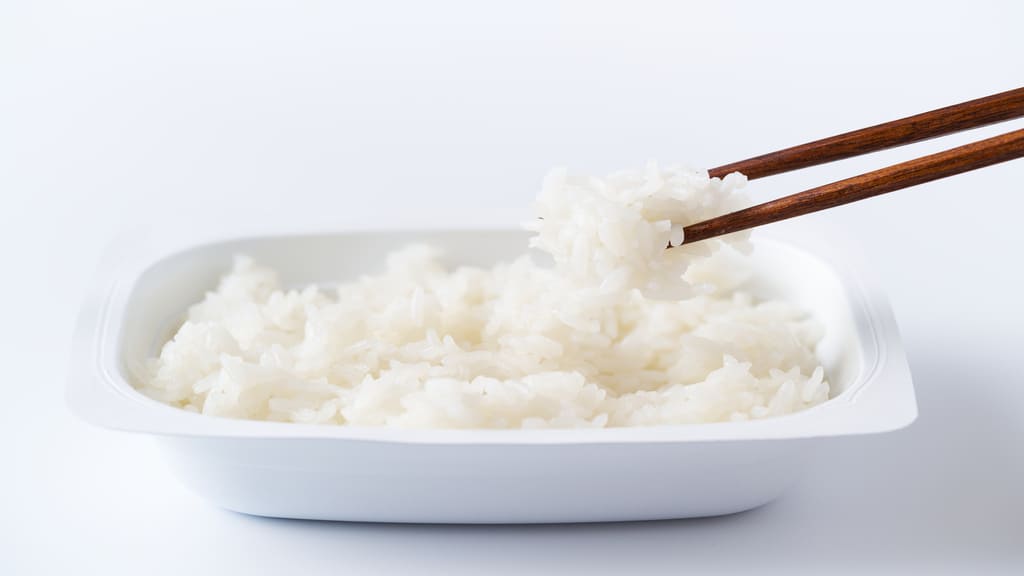 パックご飯を箸で持ち上げる様子