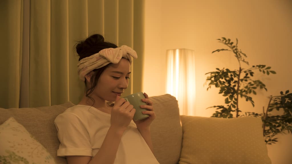 リラックスしながら温かい飲み物を飲んでいる女性
