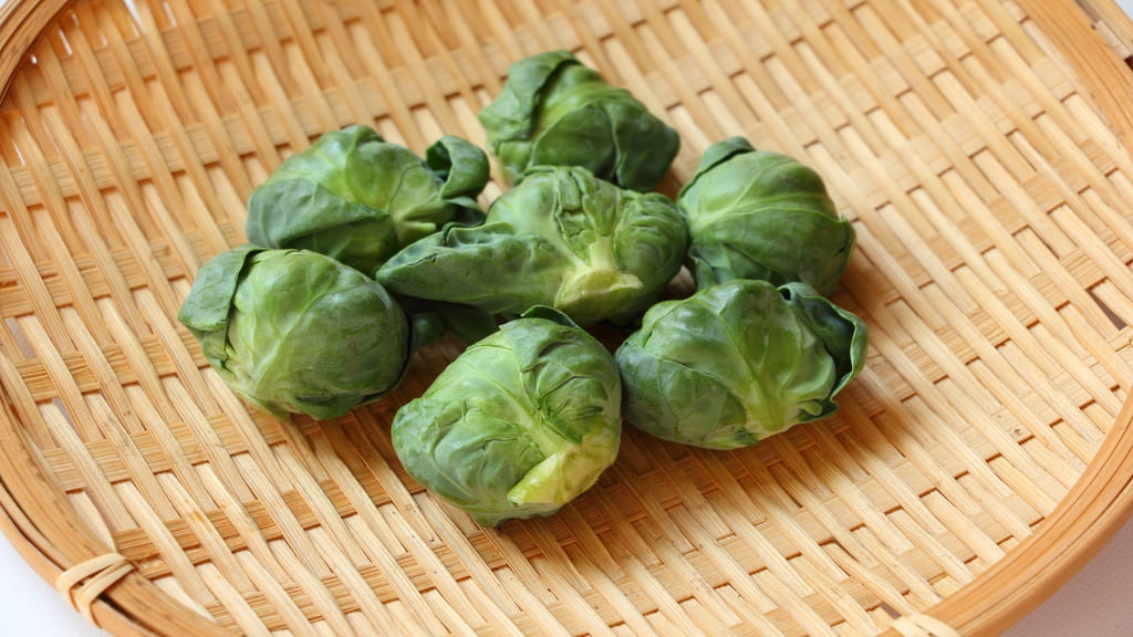 木のざるに置かれた芽キャベツ
