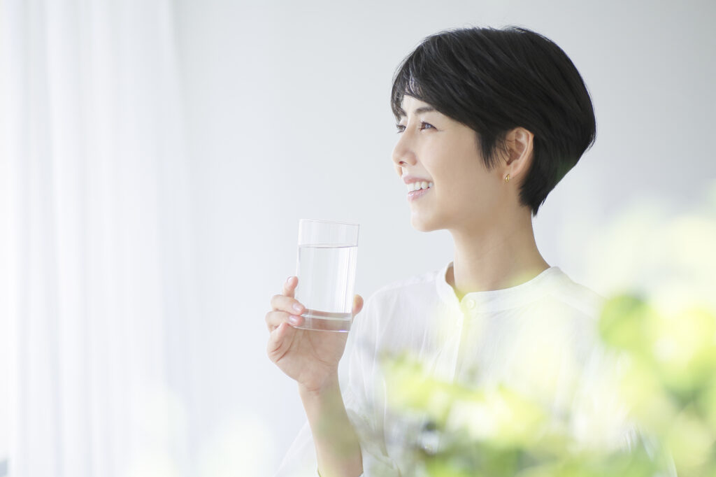 コップに入った水を持つ笑顔の女性
