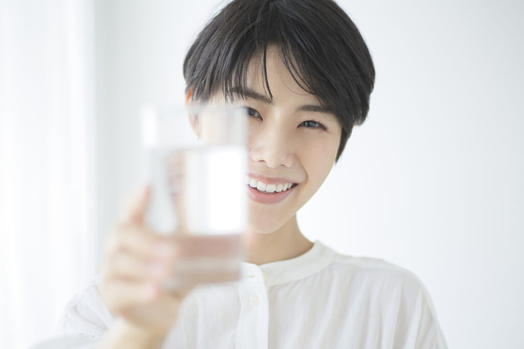 水の入ったコップを渡そうとする女性