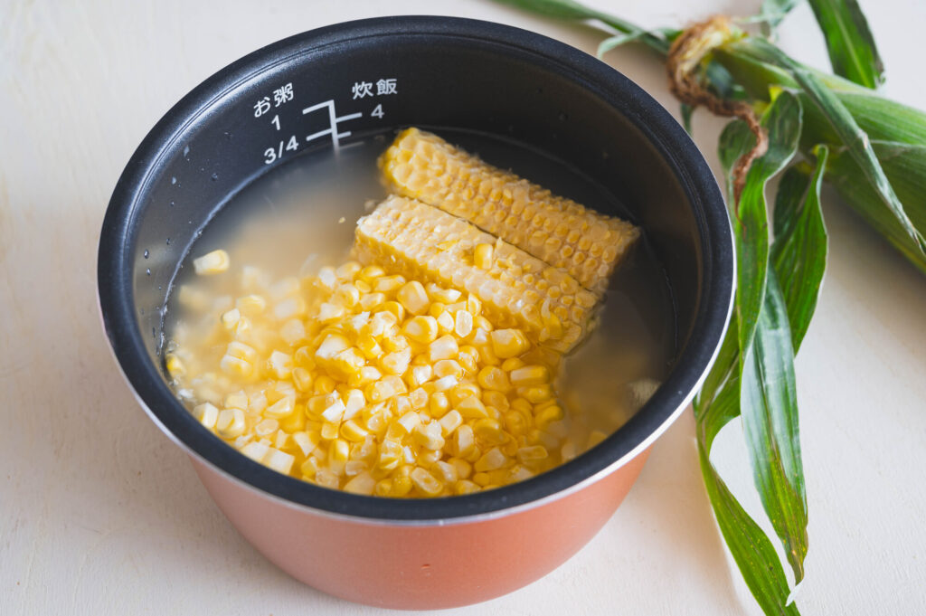 洗ったお米にとうもろこしの粒と芯を入れた炊飯釜