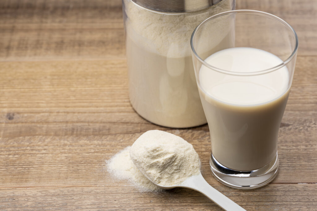 計量スプーンとグラスに注がれたプロテインドリンク