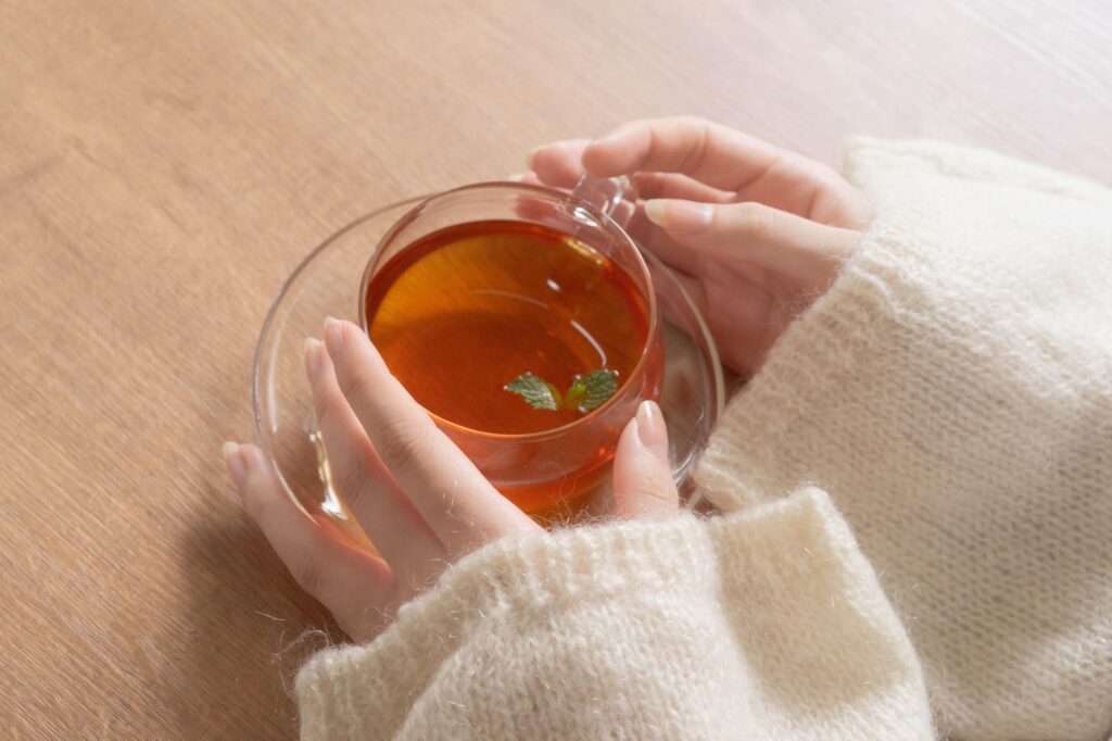 ガラスのカップを持つ女性の手