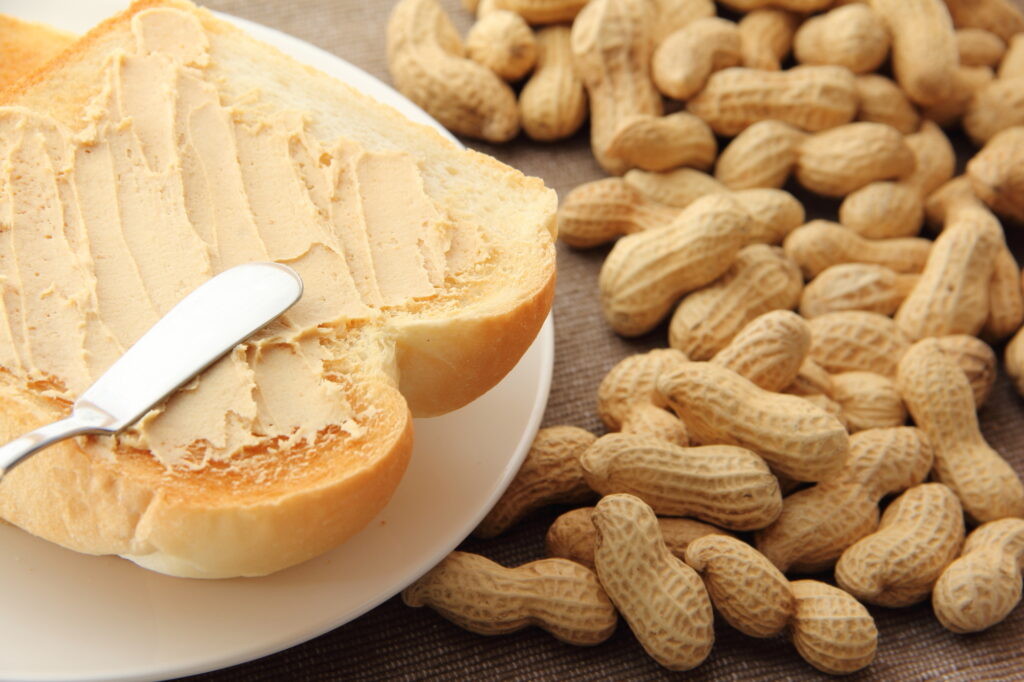 殻付きピーナッツとトーストに塗られたピーナッツバター