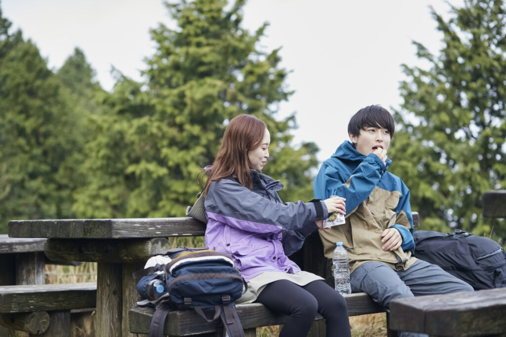 トレイルミックスを食べながら休憩する男女