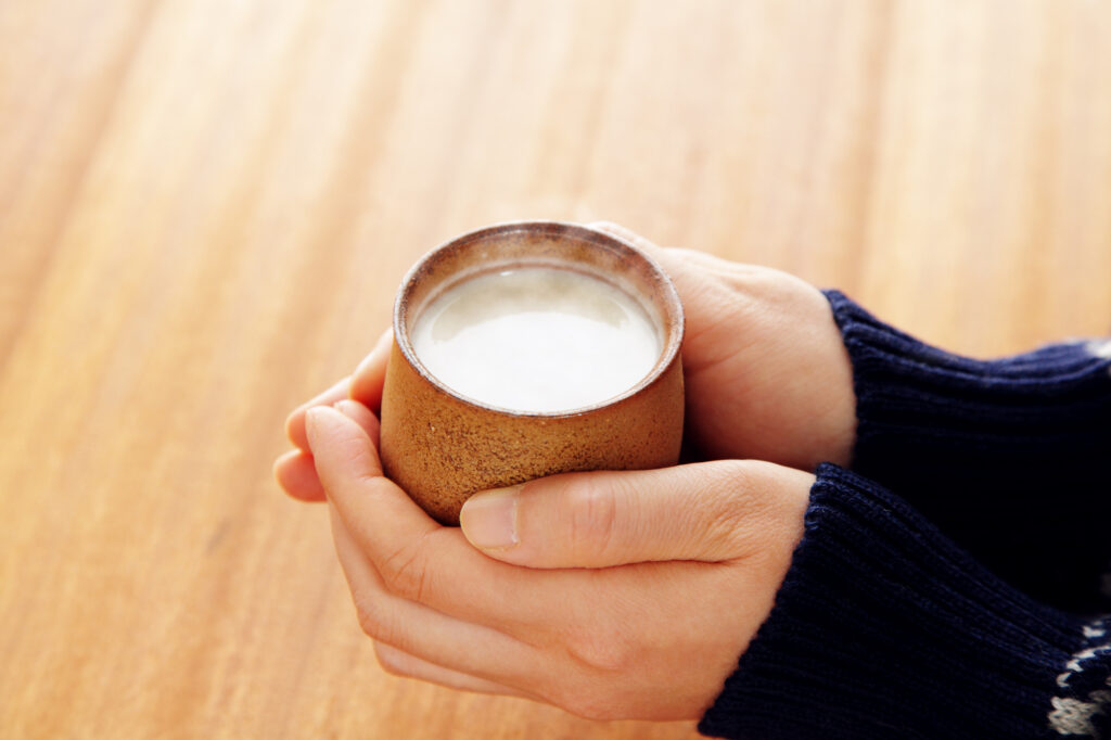 あたためた甘酒を持つ女性